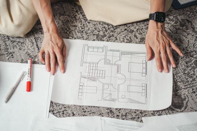 Évaluer son futur logement Un couple examine les plans d'un appartement neuf avant un achat sur plan